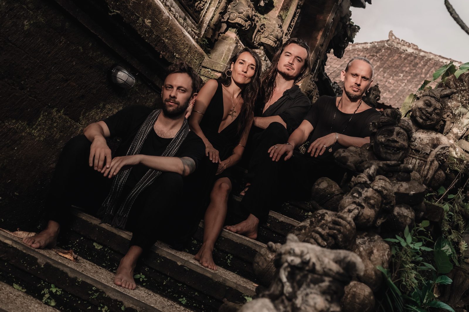 Vesper Collective, four members seated on temple steps in Bali